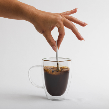 Stirring water in a cup of Waka Coffee.