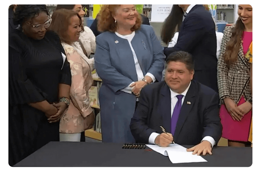 Fighting back: Gov. J.B. Pritzker signs a new law that will require the state's libraries to uphold a pledge to not ban material because of partisan disapproval. | ASSOCIATED PRESS